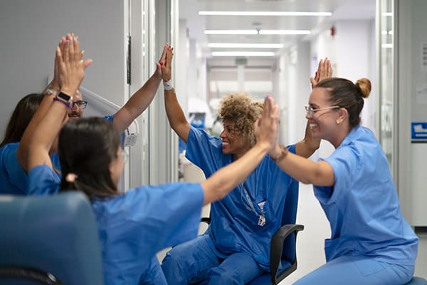 Healthcare,Professionals,In,Blue,Scrubs,Celebrating,A,Successful,Moment,In